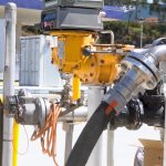 Close-up of a heavy-duty reinforced fuel hose line with industrial nozzles.